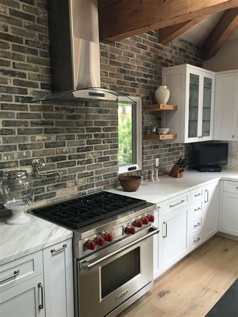 gray cabinets with brick backsplash